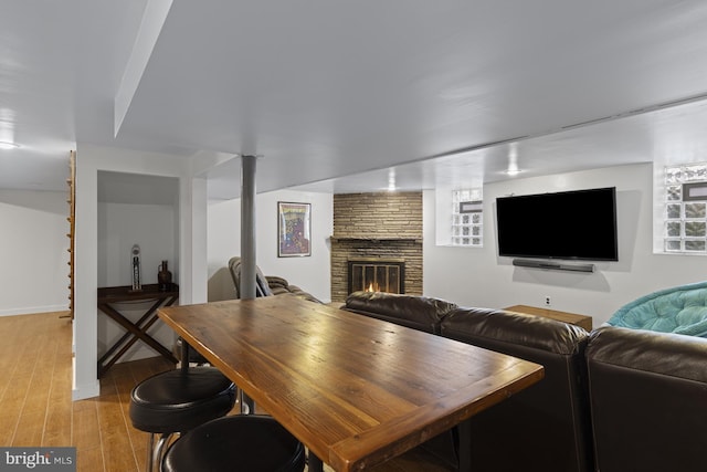 living room featuring baseboards, light wood finished floors, and a fireplace