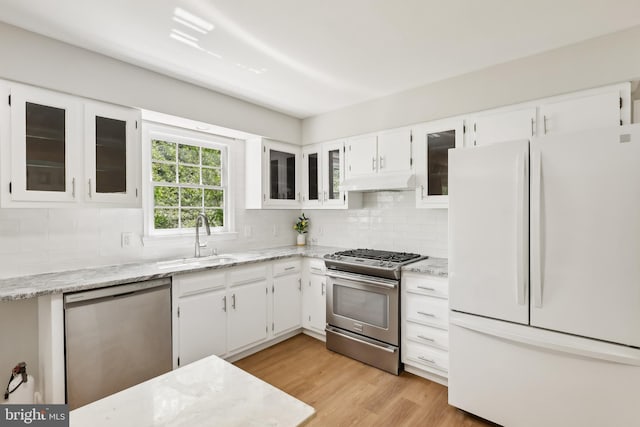 4 Virginia Rd, Glassboro, NJ 08028 - kitchen with appliances with stainless steel finishes, under cabinet range hood, a sink, tasteful backsplash, and white cabinets