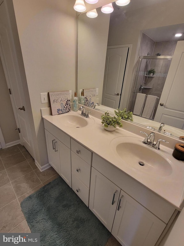 full bath featuring tile patterned flooring, a sink, double vanity, and a shower stall
