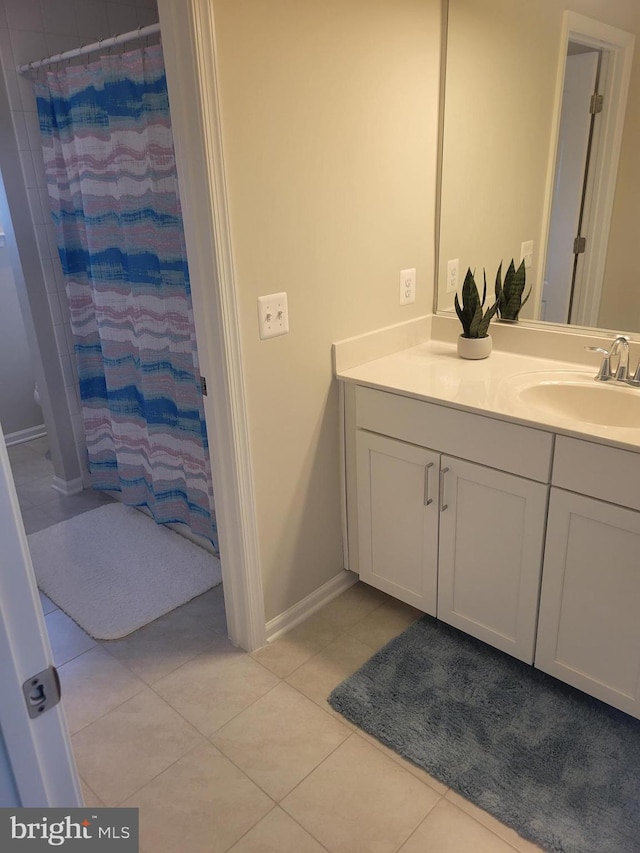 bathroom featuring baseboards, a shower with shower curtain, tile patterned flooring, and vanity