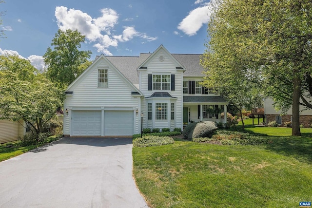 view of front of home with a garage, aphalt driveway, a front yard, a standing seam roof, and a shingled roof