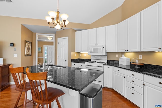 kitchen featuring white appliances, an inviting chandelier, a sink, and wood finished floors