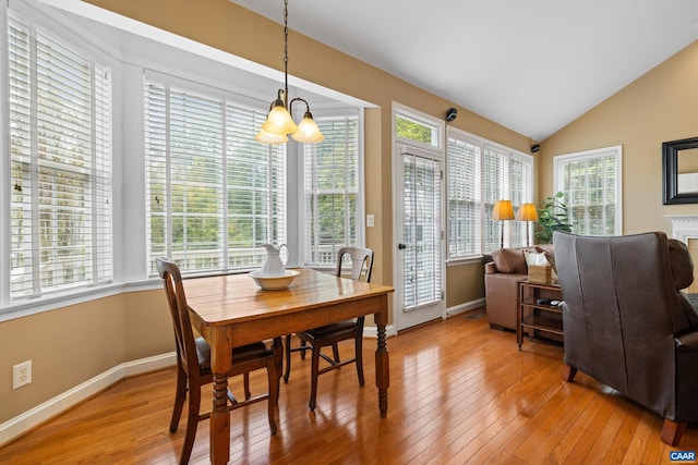 dining area featuring light wood-style floors, baseboards, a wealth of natural light, and a notable chandelier