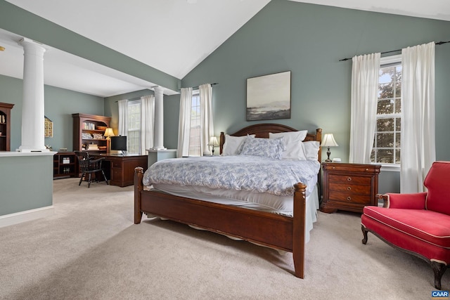 carpeted bedroom featuring decorative columns and vaulted ceiling