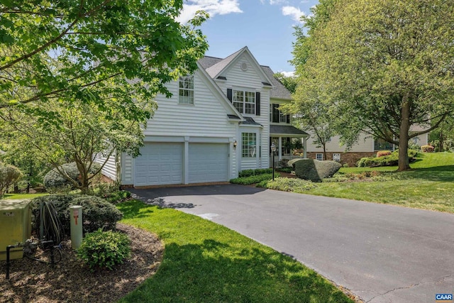 traditional-style house with an attached garage, a front lawn, and aphalt driveway