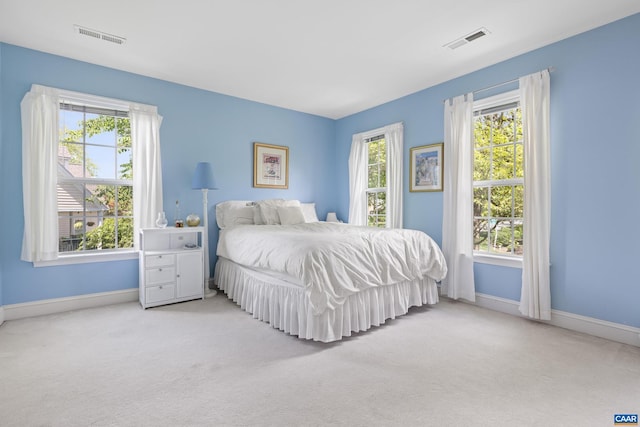 carpeted bedroom with baseboards and visible vents