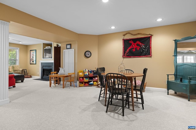 carpeted dining space featuring baseboards, a fireplace with flush hearth, a healthy amount of sunlight, and recessed lighting