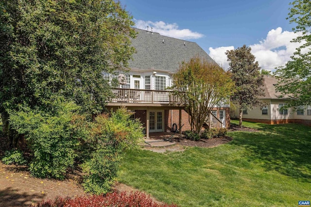 rear view of property with french doors, a wooden deck, and a yard
