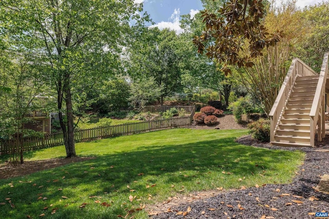 view of yard with fence and stairs