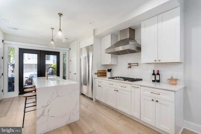 430 15th St SE, Washington, DC 20003 - kitchen featuring gas cooktop, french doors, wall chimney exhaust hood, decorative backsplash, and high quality fridge