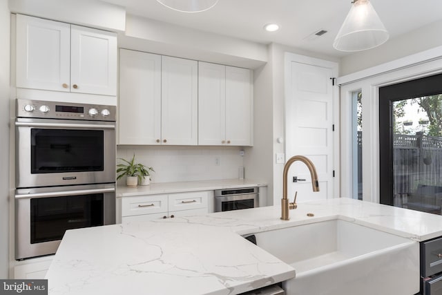 430 15th St SE, Washington, DC 20003 - kitchen featuring white cabinets, a sink, double oven, tasteful backsplash, and visible vents