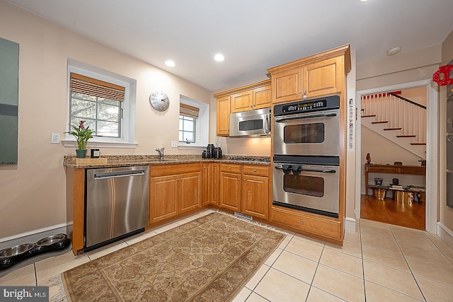 701 Argyle Rd, Wynnewood, PA 19096 - kitchen with stainless steel appliances, stone countertops, light tile patterned floors, recessed lighting, and a sink