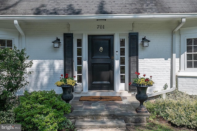701 Argyle Rd, Wynnewood, PA 19096 - doorway to property featuring brick siding, a shingled roof, and covered porch