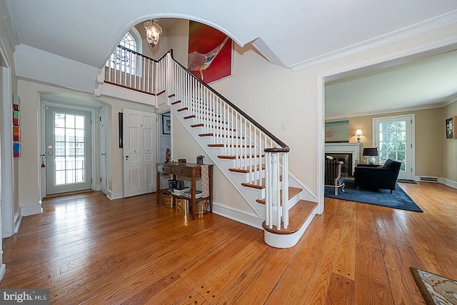 701 Argyle Rd, Wynnewood, PA 19096 - stairs with hardwood / wood-style flooring, crown molding, a fireplace, baseboards, and arched walkways