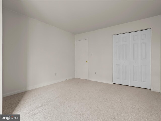 6605 Rapid Water Way Unit 301, Glen Burnie, MD 21060 - unfurnished bedroom featuring carpet floors, a closet, and baseboards