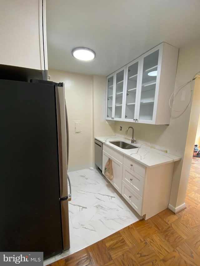 922 24th St NW Unit 517, Washington, DC 20037 - kitchen featuring stainless steel appliances, a sink, glass insert cabinets, white cabinets, and light stone counters