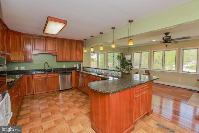 kitchen featuring stainless steel dishwasher, a peninsula, plenty of natural light, and a sink