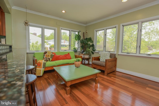 sunroom with baseboards, ornamental molding, recessed lighting, and hardwood / wood-style flooring