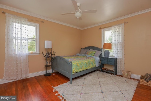 bedroom featuring crown molding, baseboards, multiple windows, and wood-type flooring