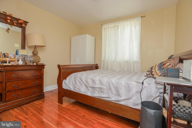 bedroom with baseboards and wood finished floors