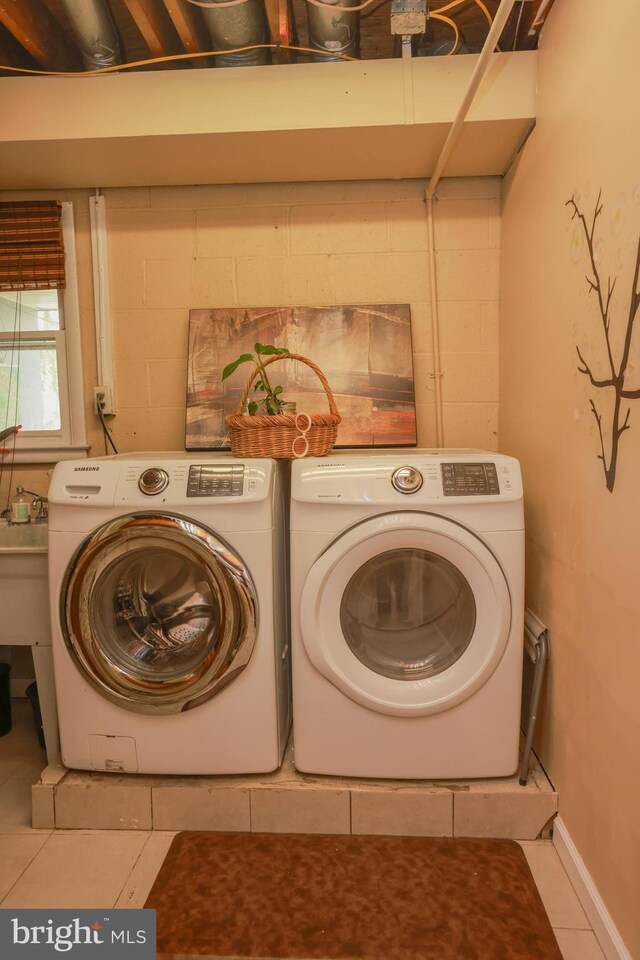 laundry area with laundry area, independent washer and dryer, tile patterned flooring, and concrete block wall