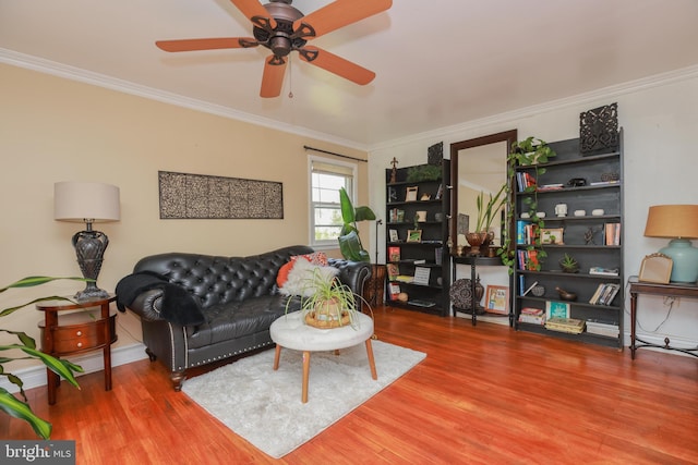 living room with ceiling fan, baseboards, ornamental molding, and wood finished floors