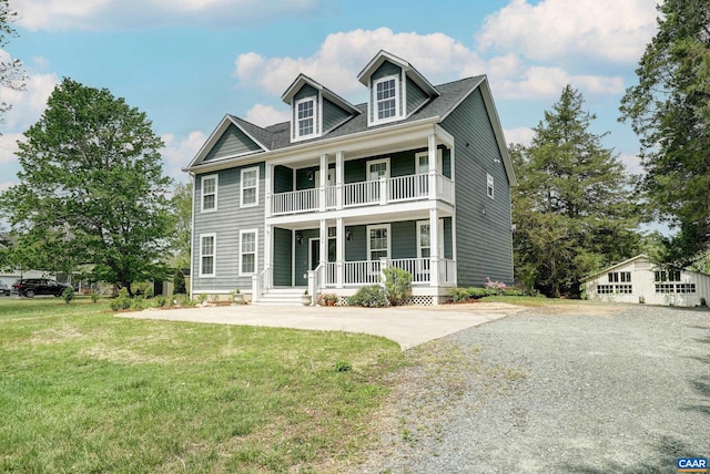 greek revival inspired property with a porch, a balcony, and a front yard