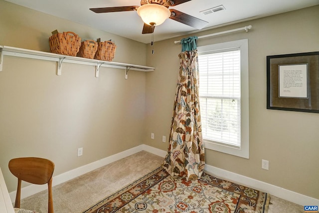 interior space featuring carpet flooring, a ceiling fan, baseboards, and visible vents