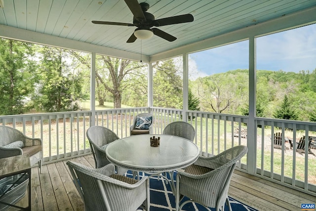 sunroom / solarium featuring ceiling fan and outdoor dining area