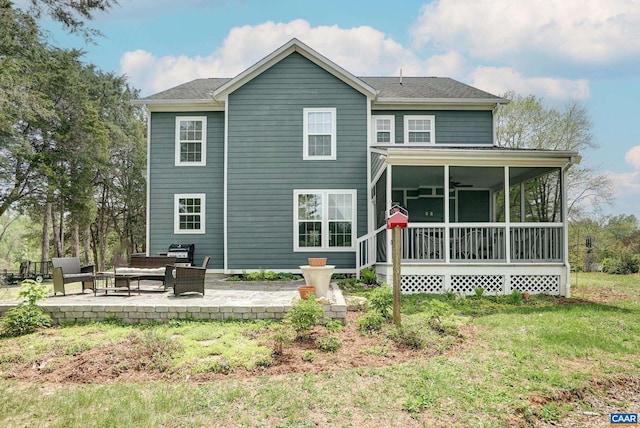rear view of house featuring a ceiling fan, a sunroom, and a patio area
