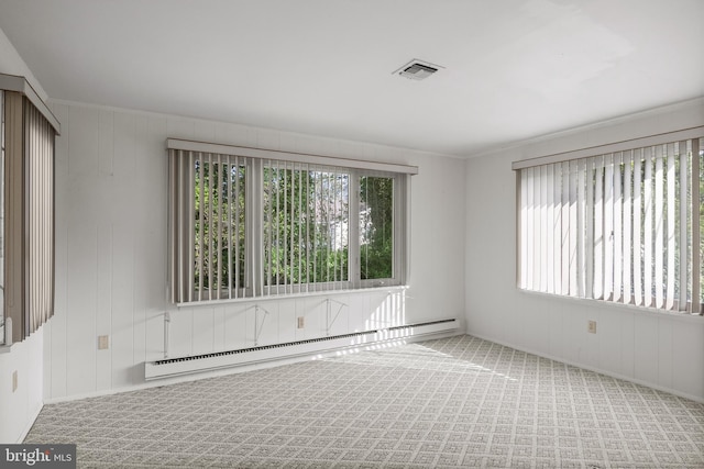 unfurnished room with plenty of natural light, a baseboard heating unit, carpet flooring, and visible vents