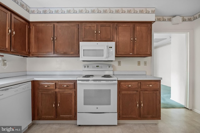 kitchen with white appliances, brown cabinetry, and light countertops