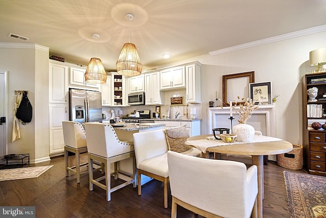23286 Southdown Manor Ter Unit 108, Ashburn, VA 20148 - kitchen with a kitchen breakfast bar, visible vents, appliances with stainless steel finishes, a center island, and ornamental molding
