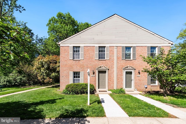 view of front of property featuring a front lawn and brick siding