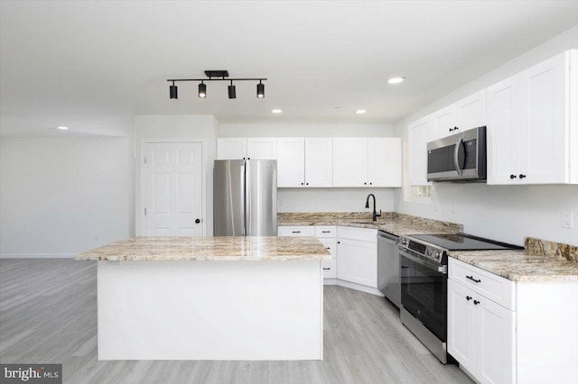 4205 Cabin Creek Hurlock Rd, Hurlock, MD 21643 - kitchen with a center island, light wood-type flooring, white cabinetry, a sink, and stainless steel appliances