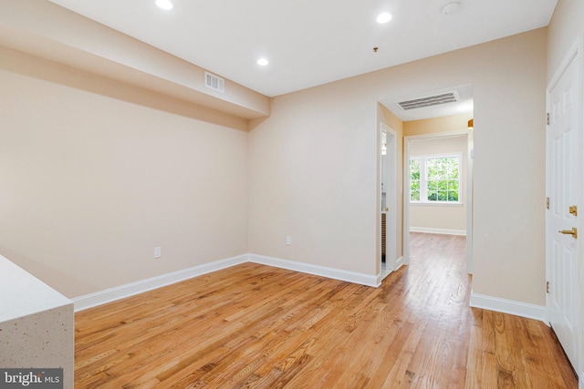 spare room with baseboards, recessed lighting, light wood-style flooring, and visible vents