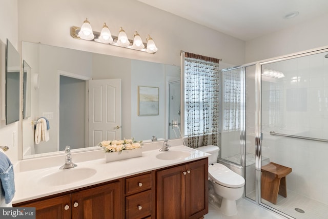 bathroom with double vanity, toilet, a sink, and a stall shower
