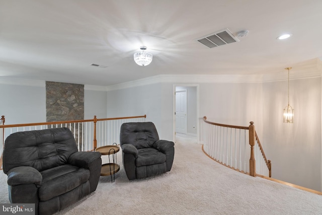 sitting room featuring visible vents, ornamental molding, and an upstairs landing