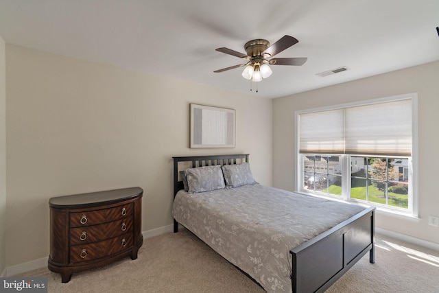 bedroom featuring baseboards, ceiling fan, light carpet, and visible vents