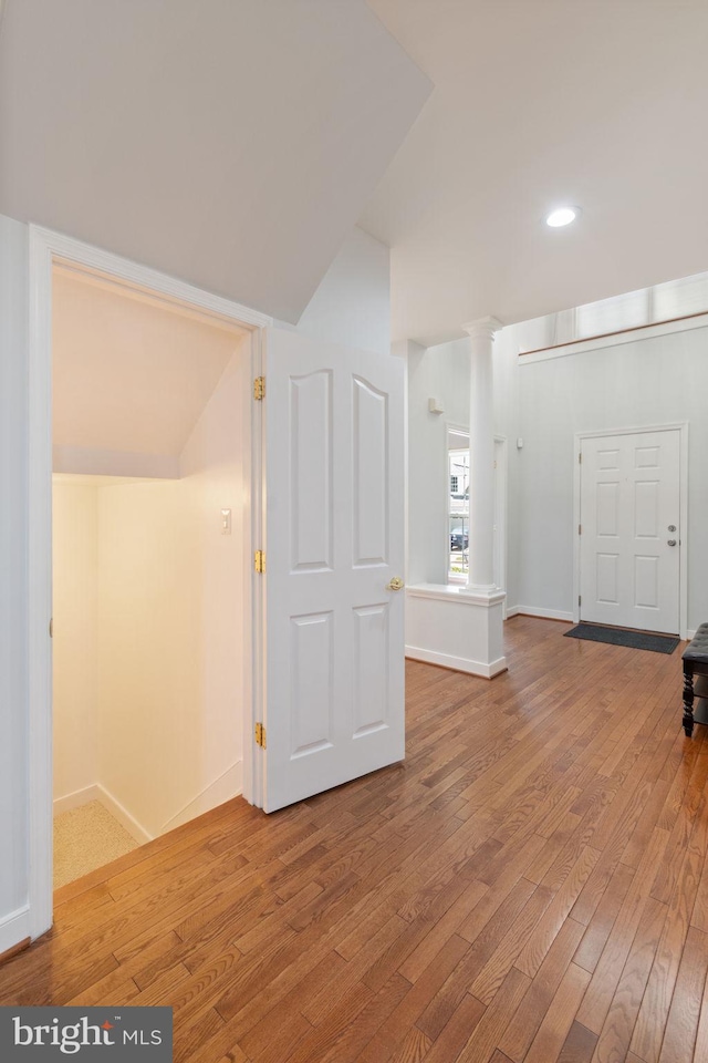 additional living space with wood-type flooring, recessed lighting, decorative columns, and baseboards