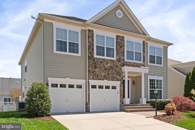 view of front of house with an attached garage, central AC, stone siding, and concrete driveway