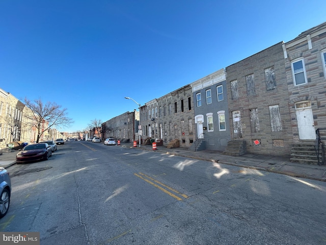 view of road featuring street lighting, sidewalks, entry steps, and curbs