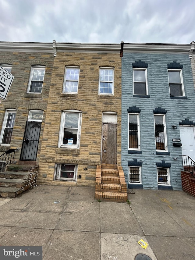 townhome / multi-family property with stone siding and entry steps
