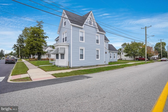25 E High St, Felton, DE 19943 - view of side of property featuring a shingled roof and a yard