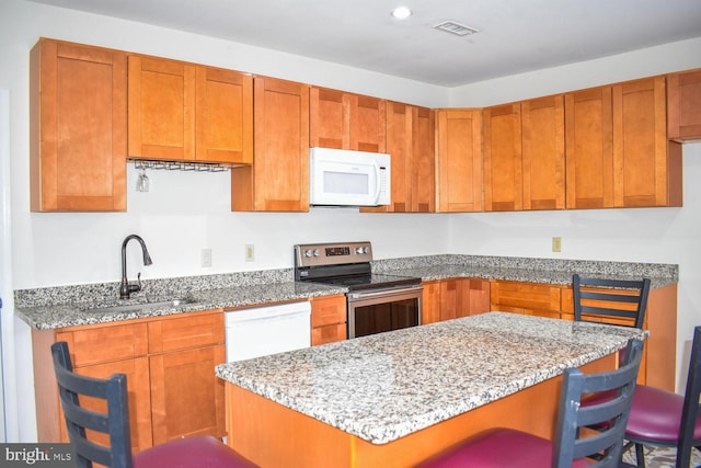 25 E High St, Felton, DE 19943 - kitchen featuring white appliances, light stone countertops, a breakfast bar area, a kitchen island, and recessed lighting