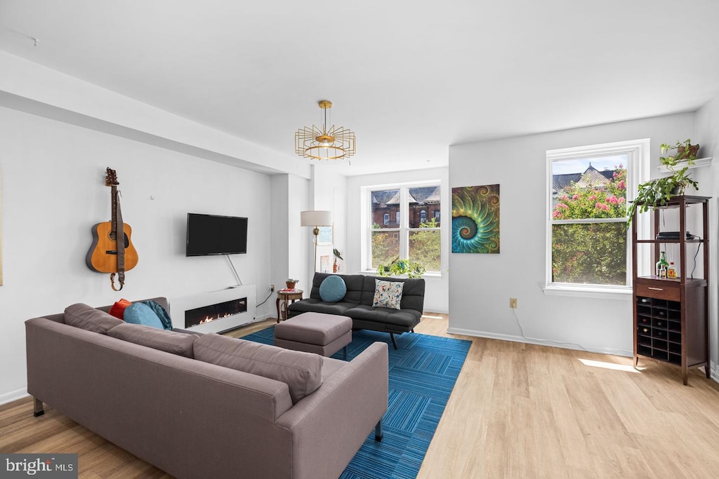 living room with wood finished floors, baseboards, and a chandelier