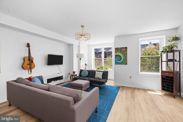 living room with wood finished floors, baseboards, and a chandelier