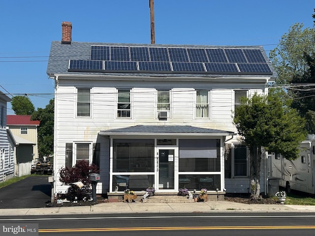 6 N Railroad Ave, Wyoming, DE 19934 - view of front of home with a sunroom, a chimney, solar panels, and roof with shingles
