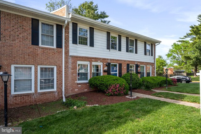 view of front of house with brick siding and a front lawn