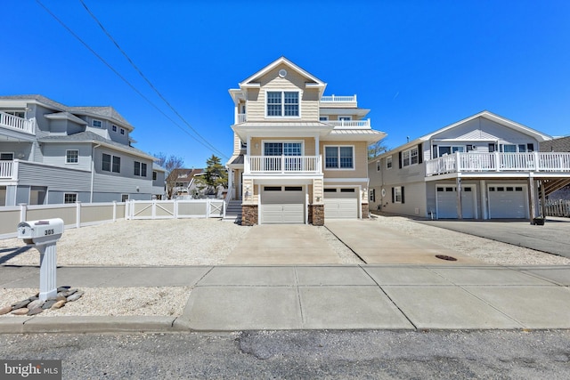 coastal inspired home featuring a standing seam roof, driveway, a balcony, an attached garage, and stone siding